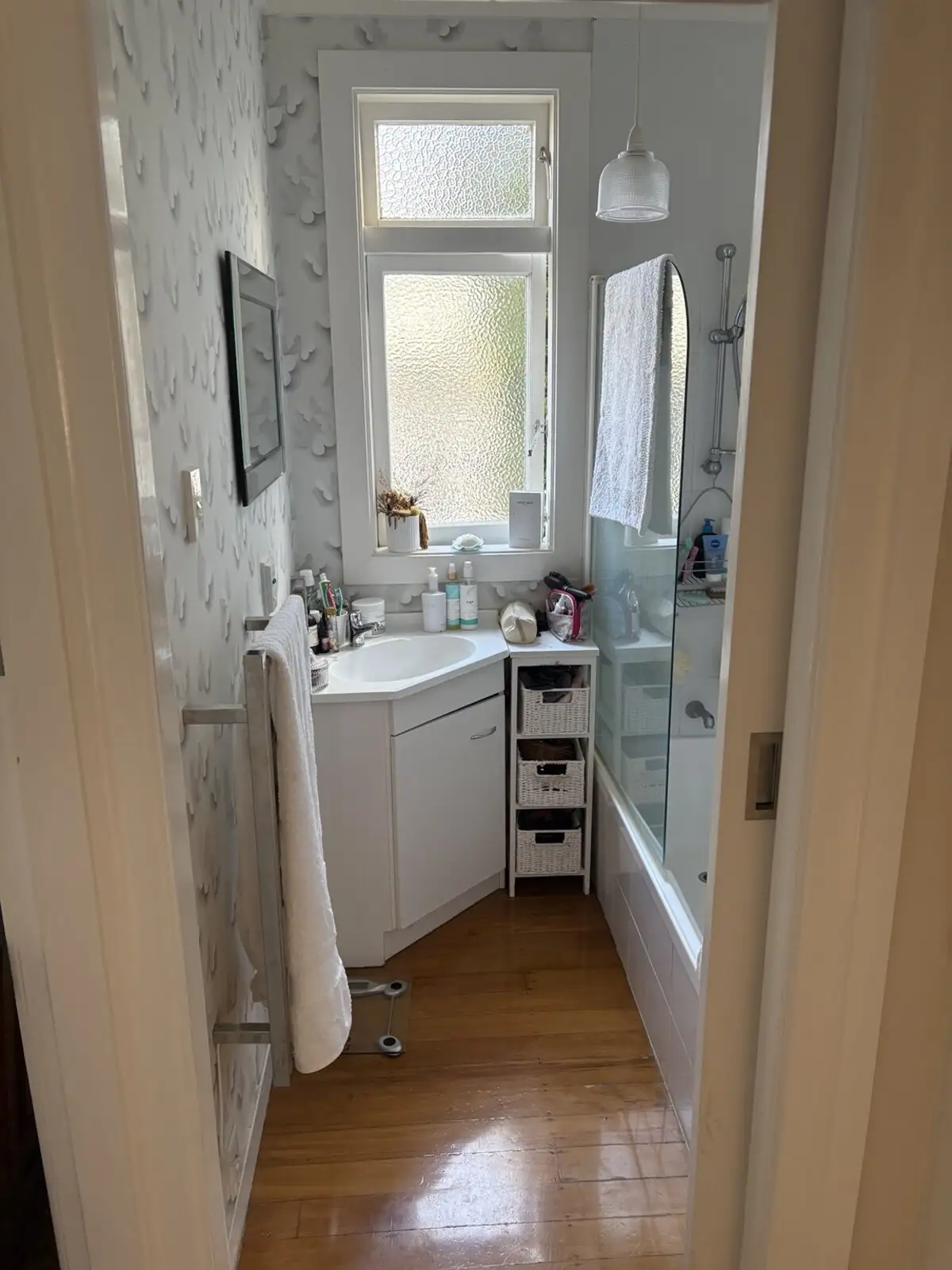 Before: dated bathroom with an old vanity and bath
