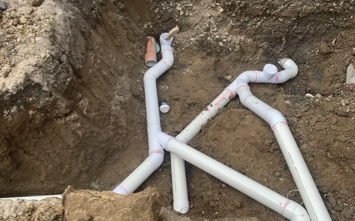 New PVC wastewater drain pipes and junctions laid in an open trench