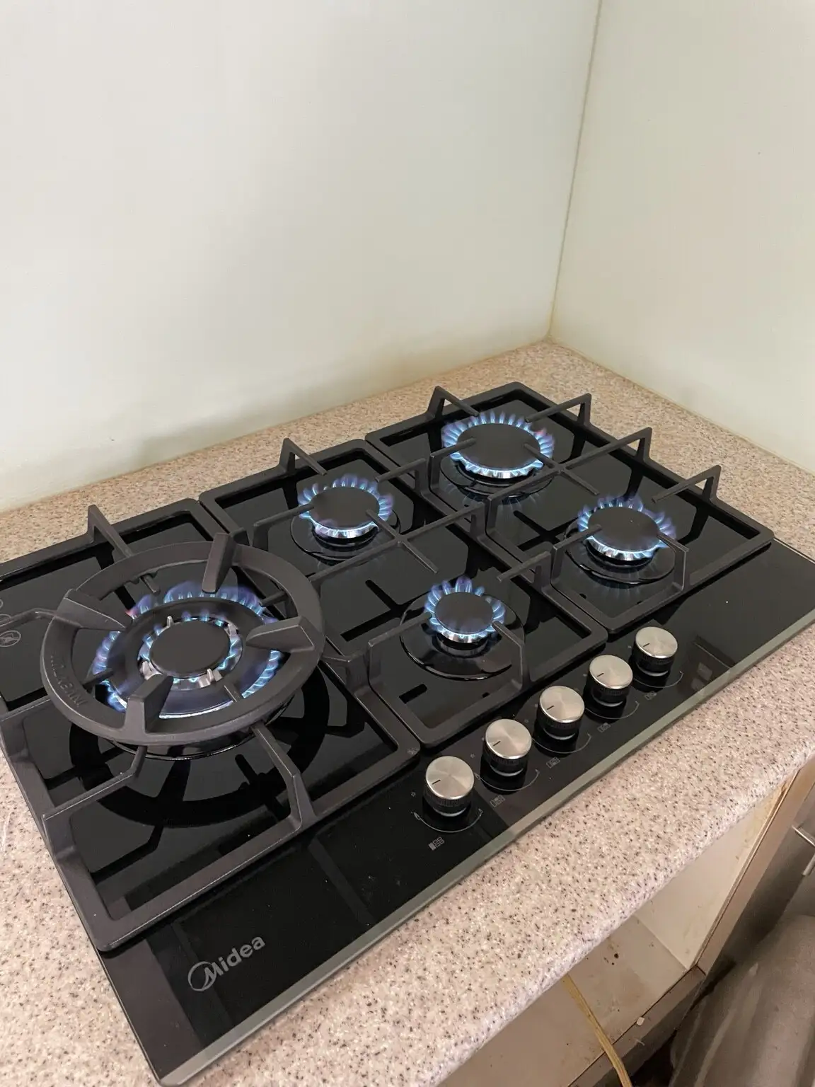 New gas hob lit on a kitchen bench