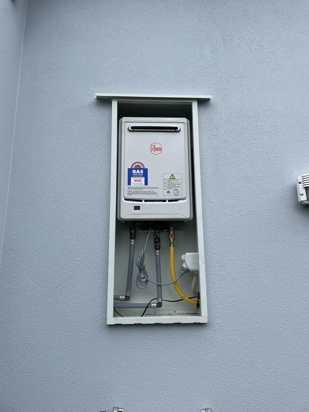Rheem continuous flow gas water heater on a grey wall