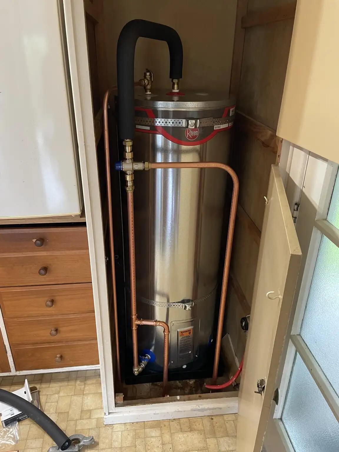 Rheem hot water cylinder installed in a laundry cupboard