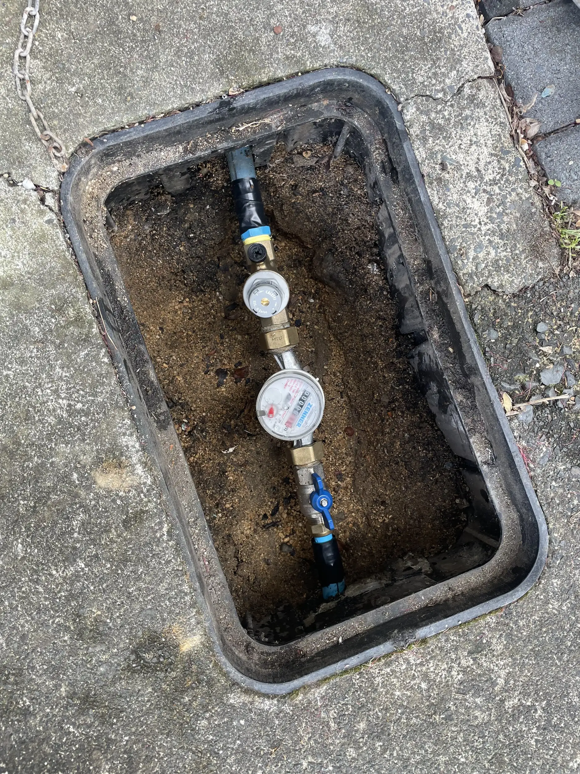 An Auckland water meter box opened up, showing the meter and the valve on the property side
